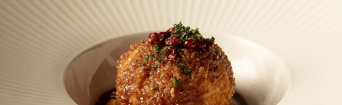 Perse's special Tahchin, served on a beautiful plate and garnished with barberry and herbs.